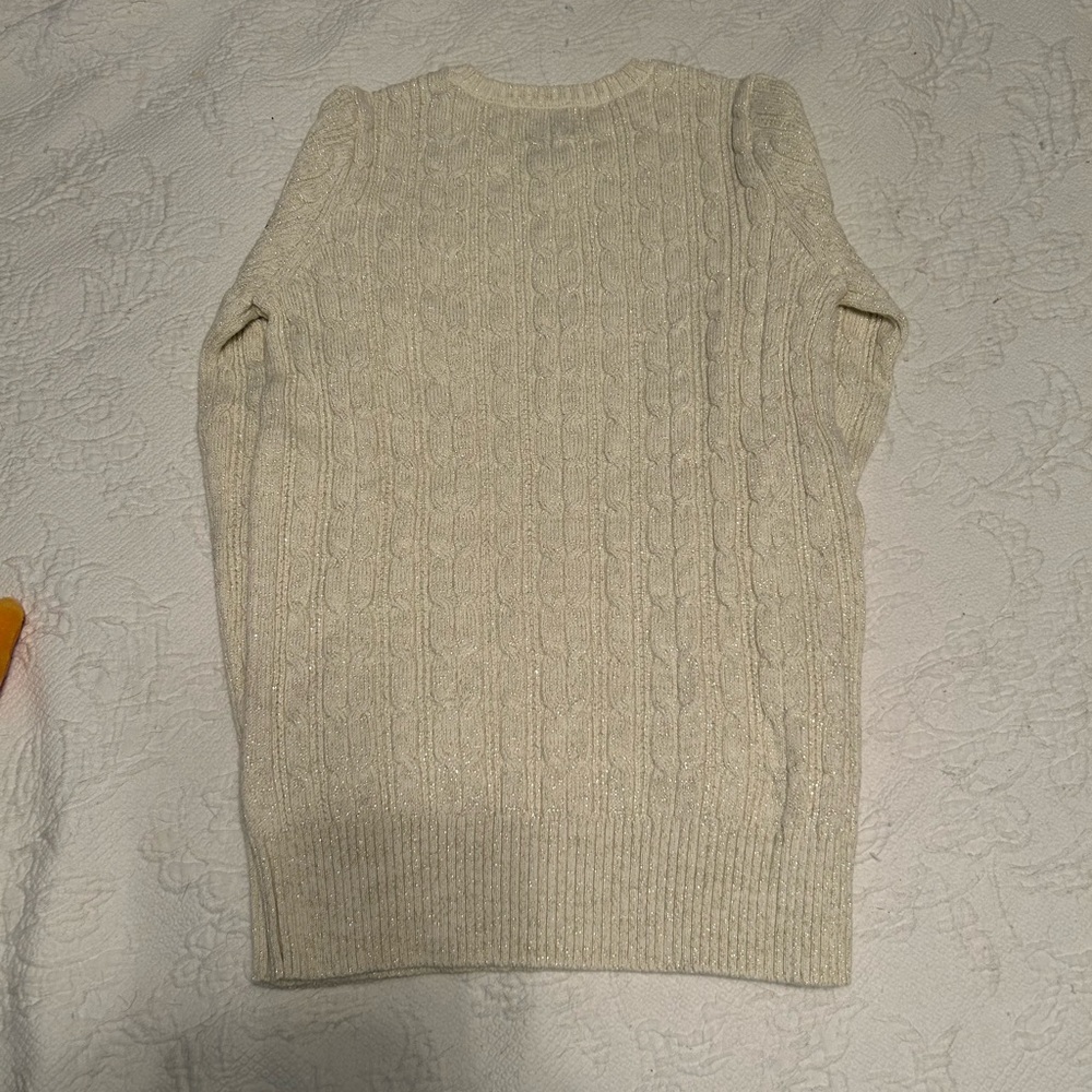 St. John’s Bay Sweater sliver thread, running through the white sweater. Size S